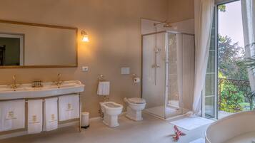 Een badkamer met een grote spiegel, twee wastafels, een toilet en een douchecabine.