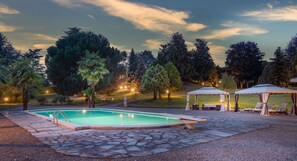 Una piscina al aire libre de temporada, sombrillas