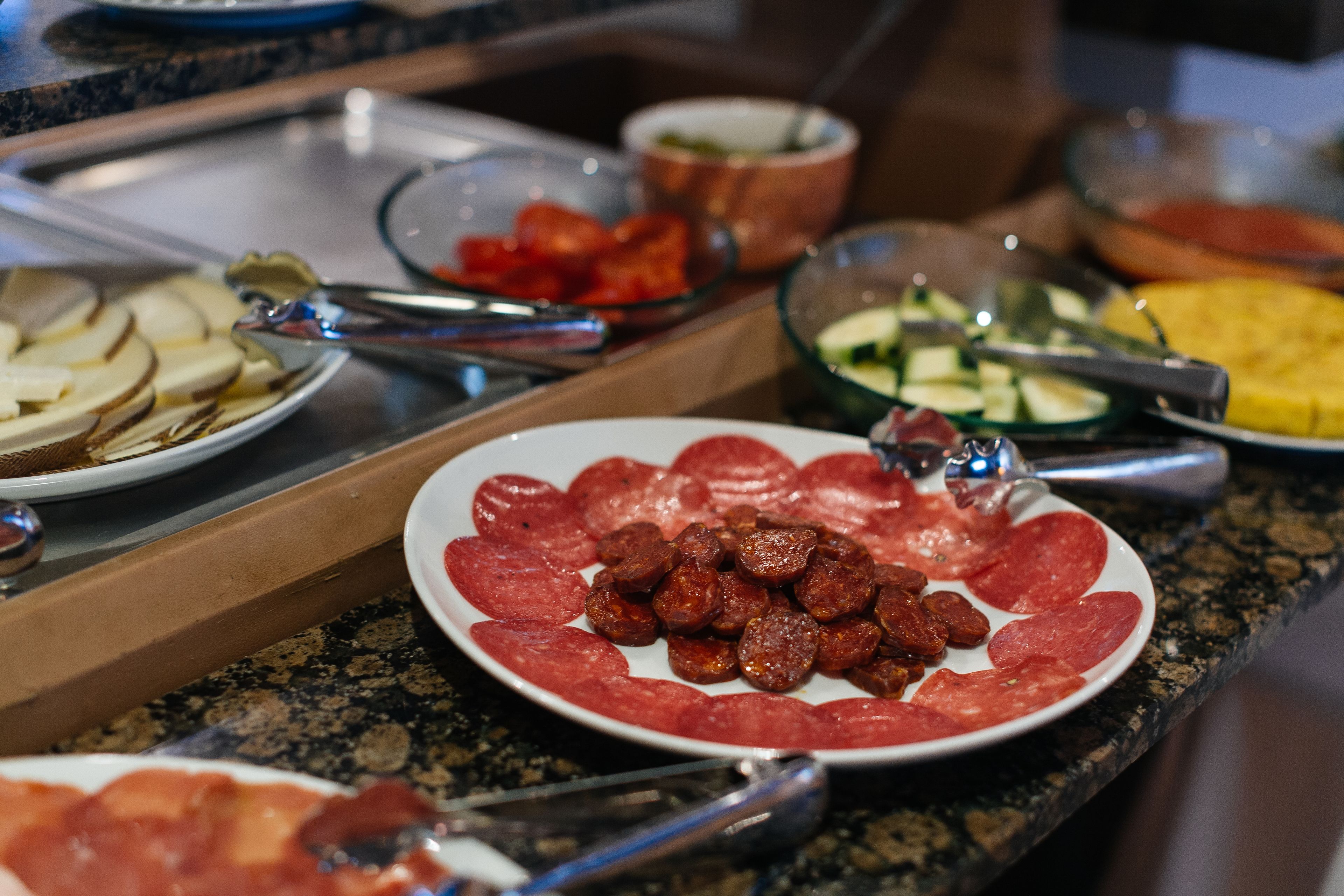 Een buffet met diverse gerechten, waaronder vleesschotels en groenten.