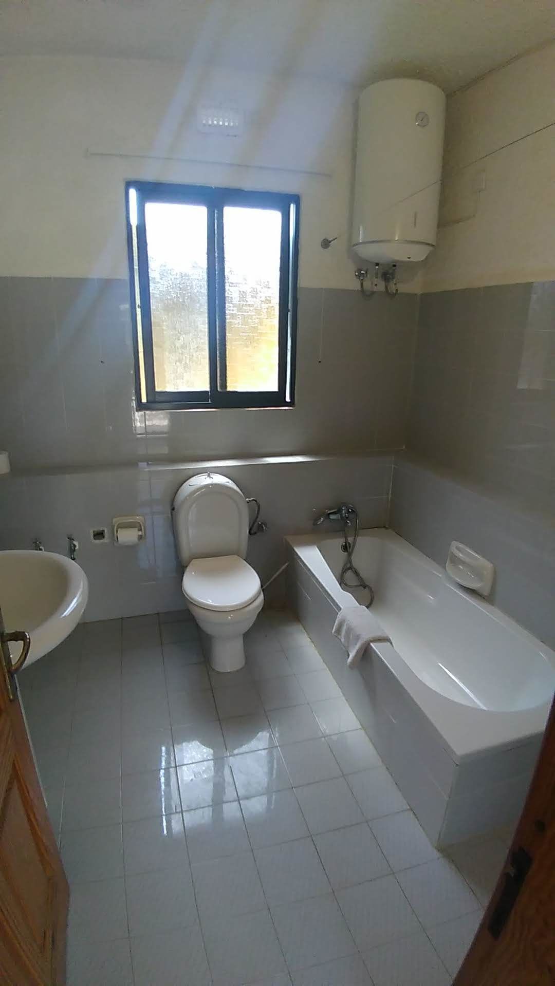 A bathroom with a toilet, sink, and bathtub.
