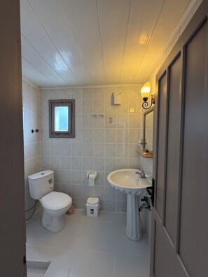A bathroom with a toilet, sink, and a window. - NEW SEDAN PANSIYON (Bodrum)