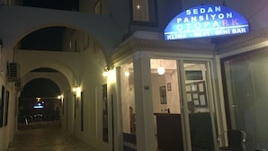 A building with a sign for Sedan Pansiyon Otopark, featuring a reception area and a mini bar. - NEW SEDAN PANSIYON (Bodrum)
