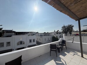 A rooftop terrace with a view of surrounding buildings, a pergola, and a few chairs. - NEW SEDAN PANSIYON (Bodrum)