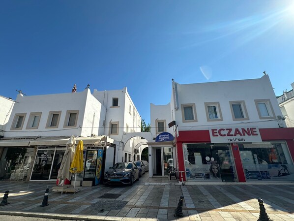 A street view with a white building featuring a sign for 'ECZANE YASEMIN'. - NEW SEDAN PANSIYON (Bodrum)