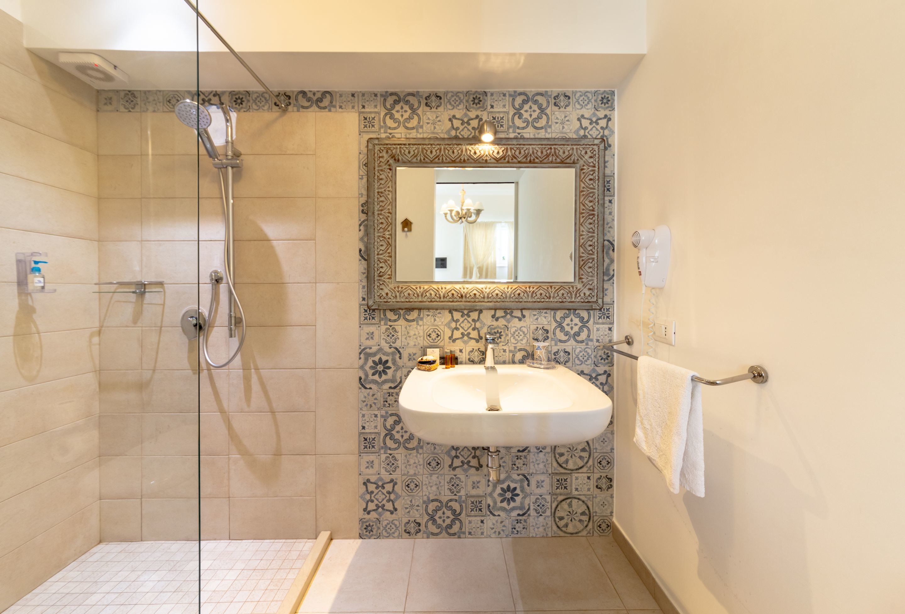 A bathroom with a shower, a sink, and a mirror.