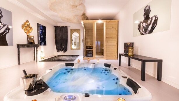 A modern spa room with a large hot tub, a wooden cabinet, and a mirror. - QuattroCuori Boutique Hotel & Spa (Portopalo di Capo Passero)