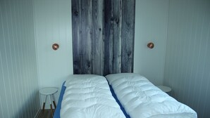 Une chambre à coucher avec un lit, un matelas bleu et une tête de lit en bois.