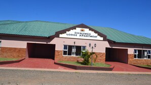 A building with a sign reading "Sikalongo Lodge Apartment" and a green roof. - Sikalongo Lodge Highlands (Livingstone)