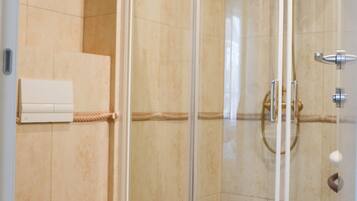 A bathroom with a glass-enclosed shower, a toilet, and a towel rack.