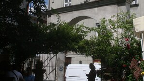 Un edificio con tetto rosso, numerose finestre e un arco ben visibile.