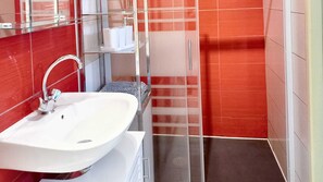 Bathroom features a white sink, chrome faucet, and a red and white tile pattern.