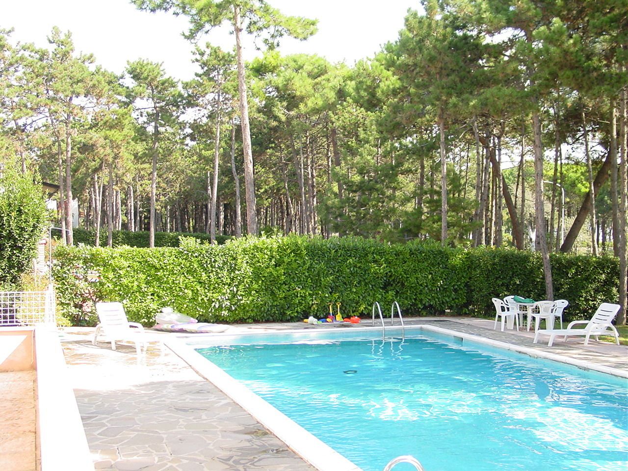 En säsongsöppen utomhuspool och solstolar