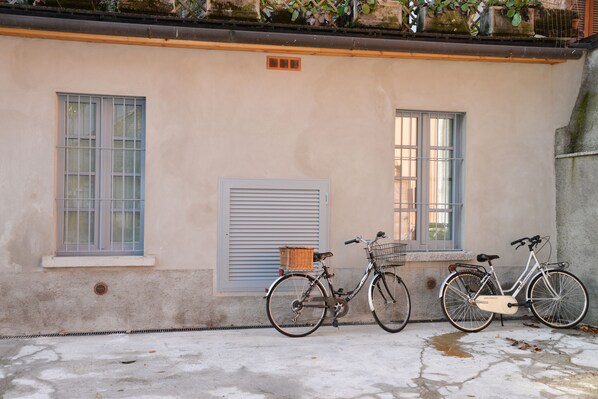 A building with two windows, a door, and a bicycle parked outside.