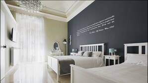 Une chambre à coucher moderne avec un grand lit, des tables de chevet, un miroir et une citation affichée sur le mur.