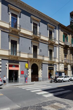 Un edificio de varios pisos con una tienda en la planta baja y una entrada visible.