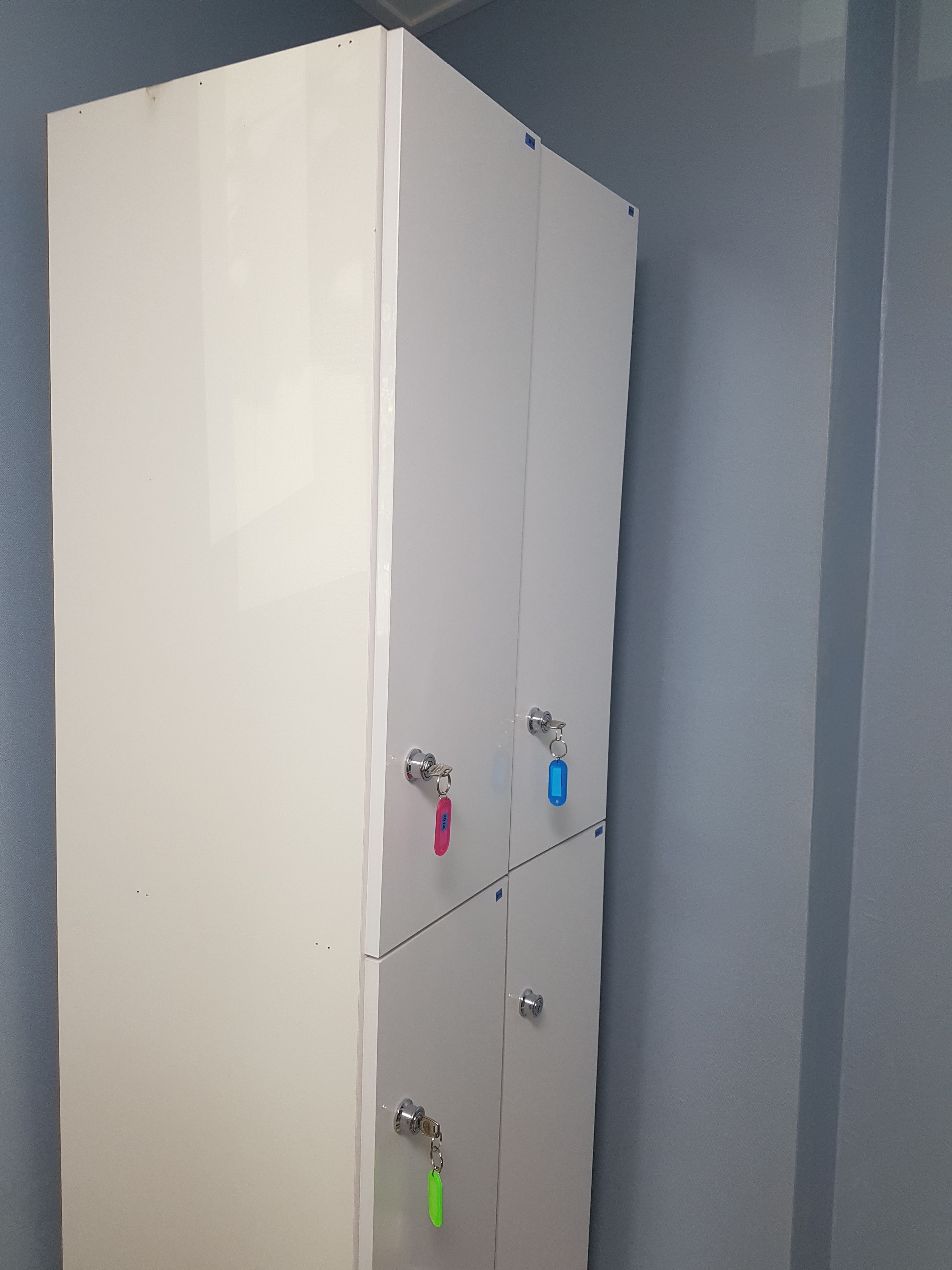 Un meuble blanc à deux portes, chacune munie d’un porte-clés.