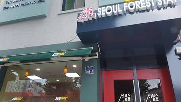 A building with a sign for 'Seoul Forest Stay' and a Subway entrance.