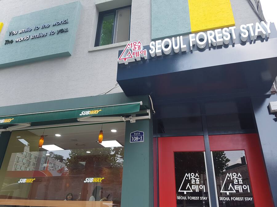 A building with a sign for 'Seoul Forest Stay' and a Subway entrance.