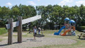 Un parque infantil con sube y baja, tobogán y estructuras para escalar.