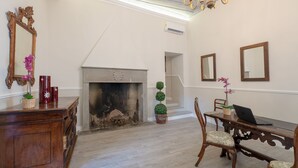 A room with a fireplace, wooden furniture, and a laptop on a table. - Residenza d'Epoca la Basilica by Mamo Florence (Florence)