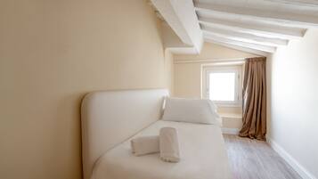A bedroom with a bed, a window, and a view of the outside.