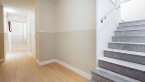 A modern interior with a wooden floor, a staircase with metal railings, and a door leading to another room. - Residenza d'Epoca la Basilica by Mamo Florence (Florence)