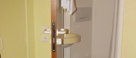 A bathroom with a toilet, sink, and a towel hanging on the wall.