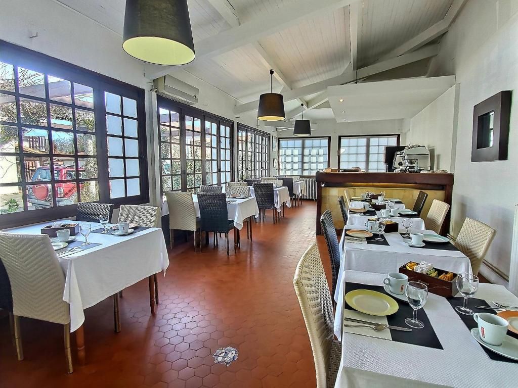 Un restaurante con varias mesas, sillas y lámparas colgantes.