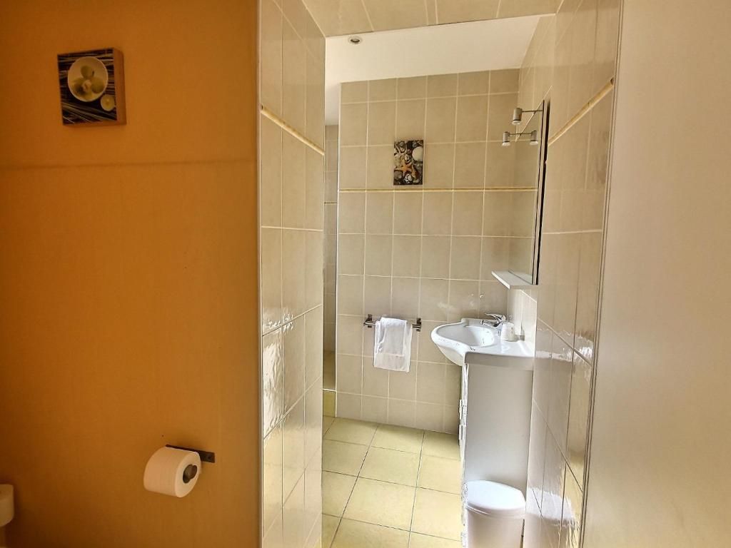 Een badkamer met toilet, wastafel en spiegel.