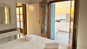 Une chambre d’hôtel avec un lit, une salle de bain et vue sur la mer.