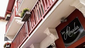 Hotelschild für "Les Almades" mit Balkon und roter Markise.