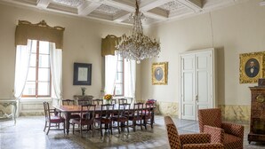 A formal dining room with a large table, chairs, and a chandelier.