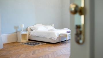 Een keurig opgemaakt slaapkamer met een bed, nachtkastje en vloerkleed.