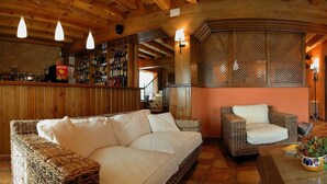 Een gezellig interieur met rieten meubels, een bar en een open haard.