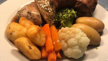 Un plato con diversos alimentos, incluyendo carne, verduras y papas.