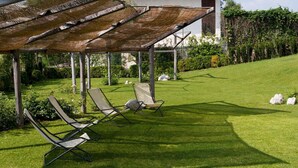 A covered outdoor seating area with two lounge chairs and a pergola structure. - La Quiete Resort (Romeno)