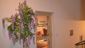 Zona de recepción de un hotel con un cartel que dice "HOTEL Anmeldung recepción".