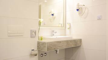 A modern bathroom with a toilet, sink, and mirror.