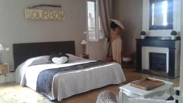 Une chambre à coucher avec un lit, une cheminée et une enseigne sur laquelle on peut lire « BOURBON ».