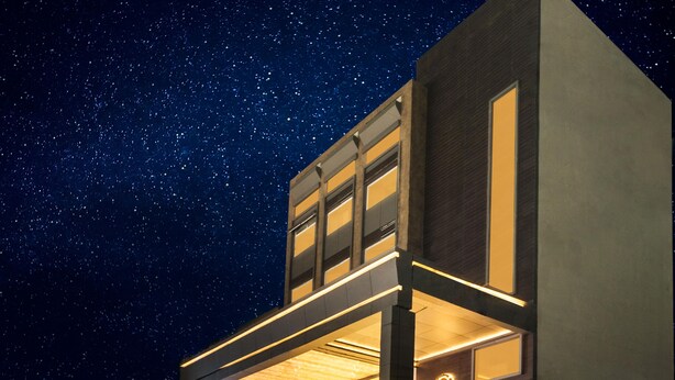 Un hotel moderno con un cielo estrellado visible a través de su estructura abierta.