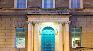 Entrada de la Galería de Arte de Dublín, con una puerta azul y columnas de estilo clásico.