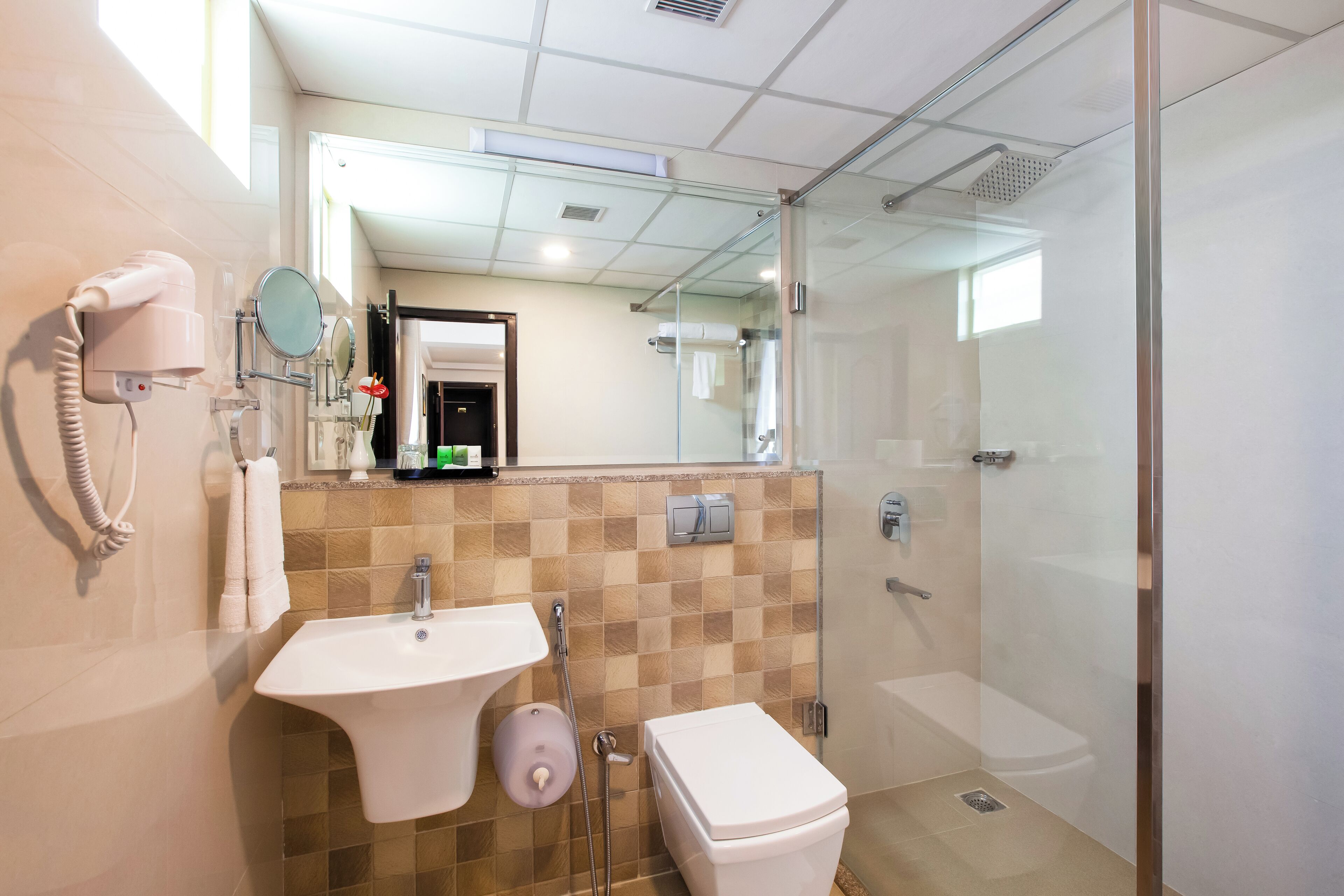 A modern bathroom with a glass-enclosed shower, a sink, and a toilet.