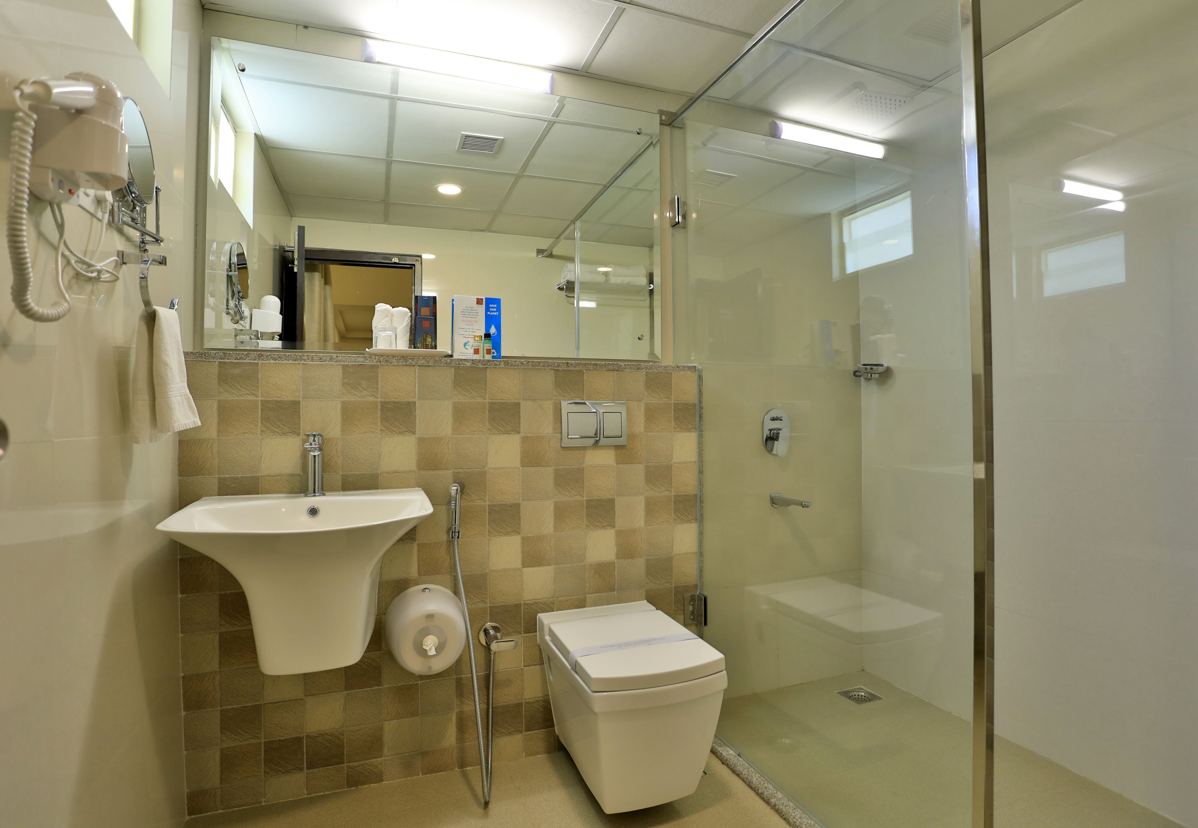 A modern bathroom with a sink, toilet, and glass shower enclosure.