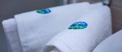 Primer plano de una toalla blanca con un logo azul y verde que dice "Fresh Hunt".