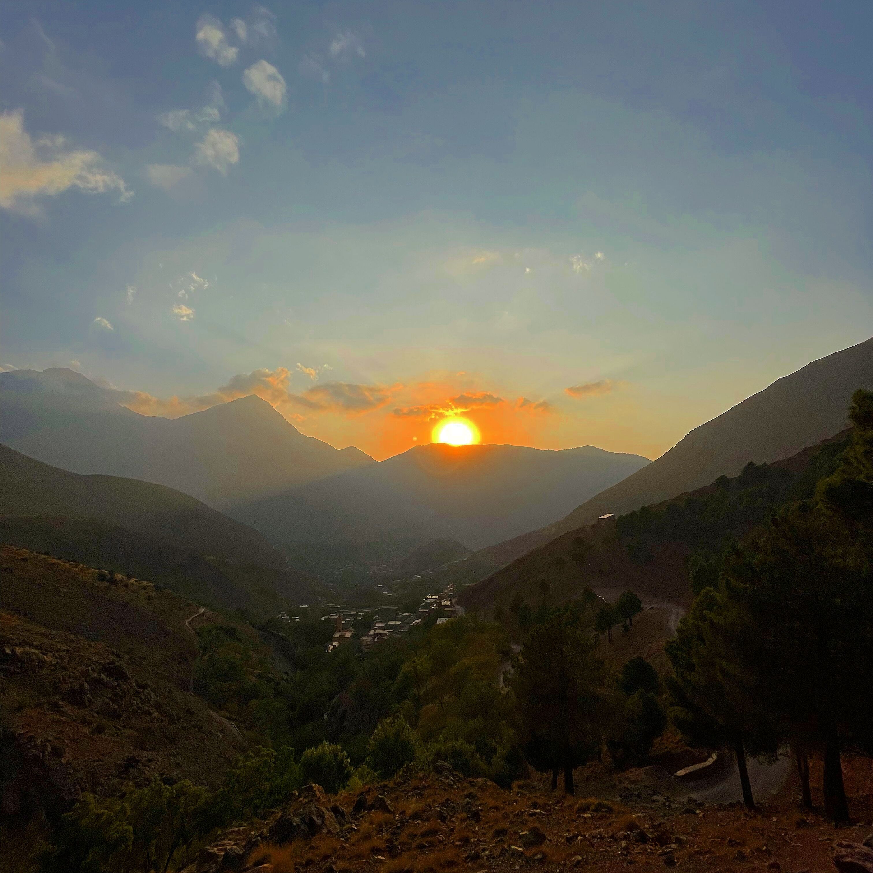 Paisagem montanhosa com um vale e um pequeno povoado.