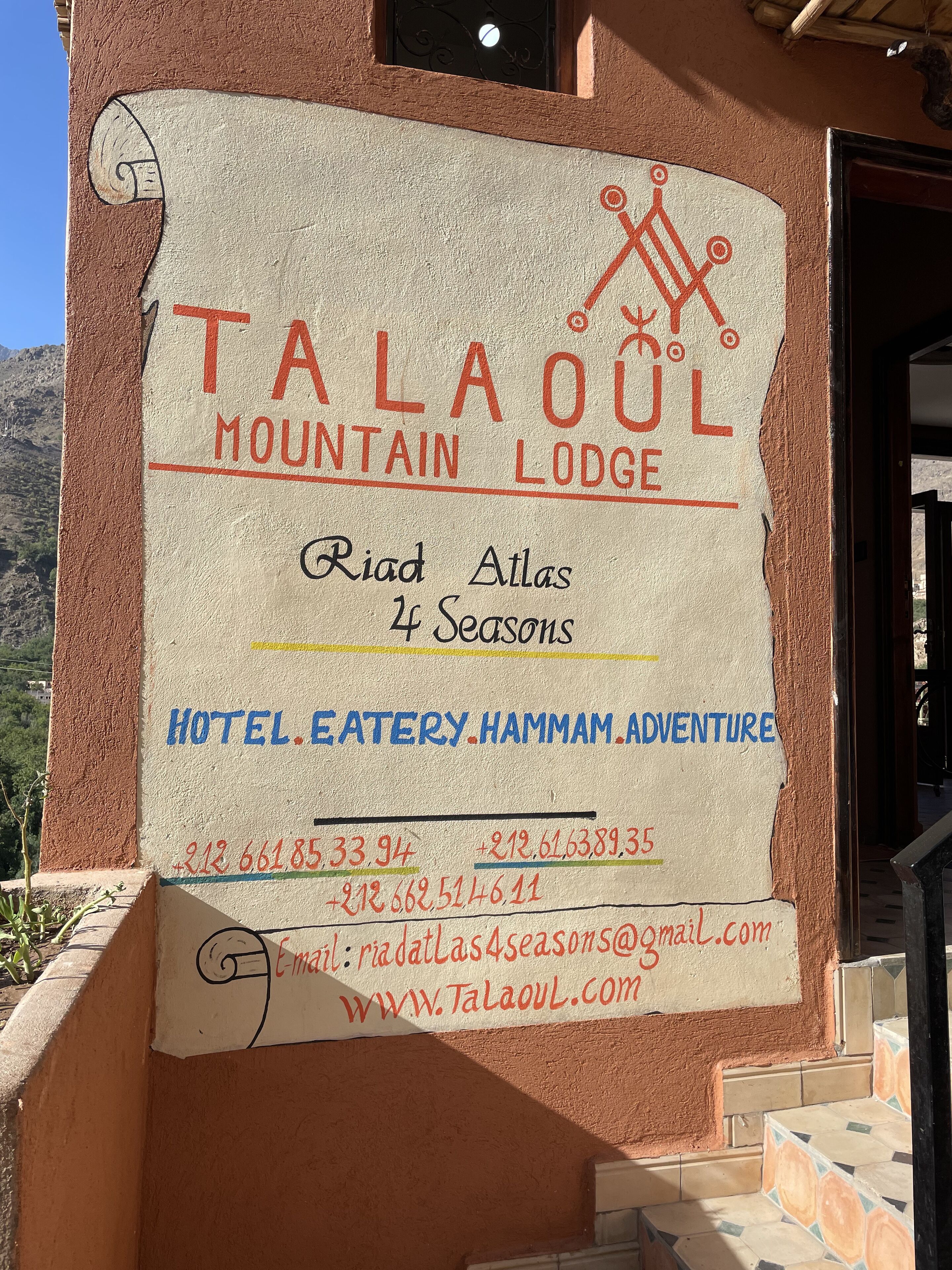Letrero de Talahol Mountain Lodge que anuncia las cuatro estaciones, hotel, restaurante y servicios de aventura.