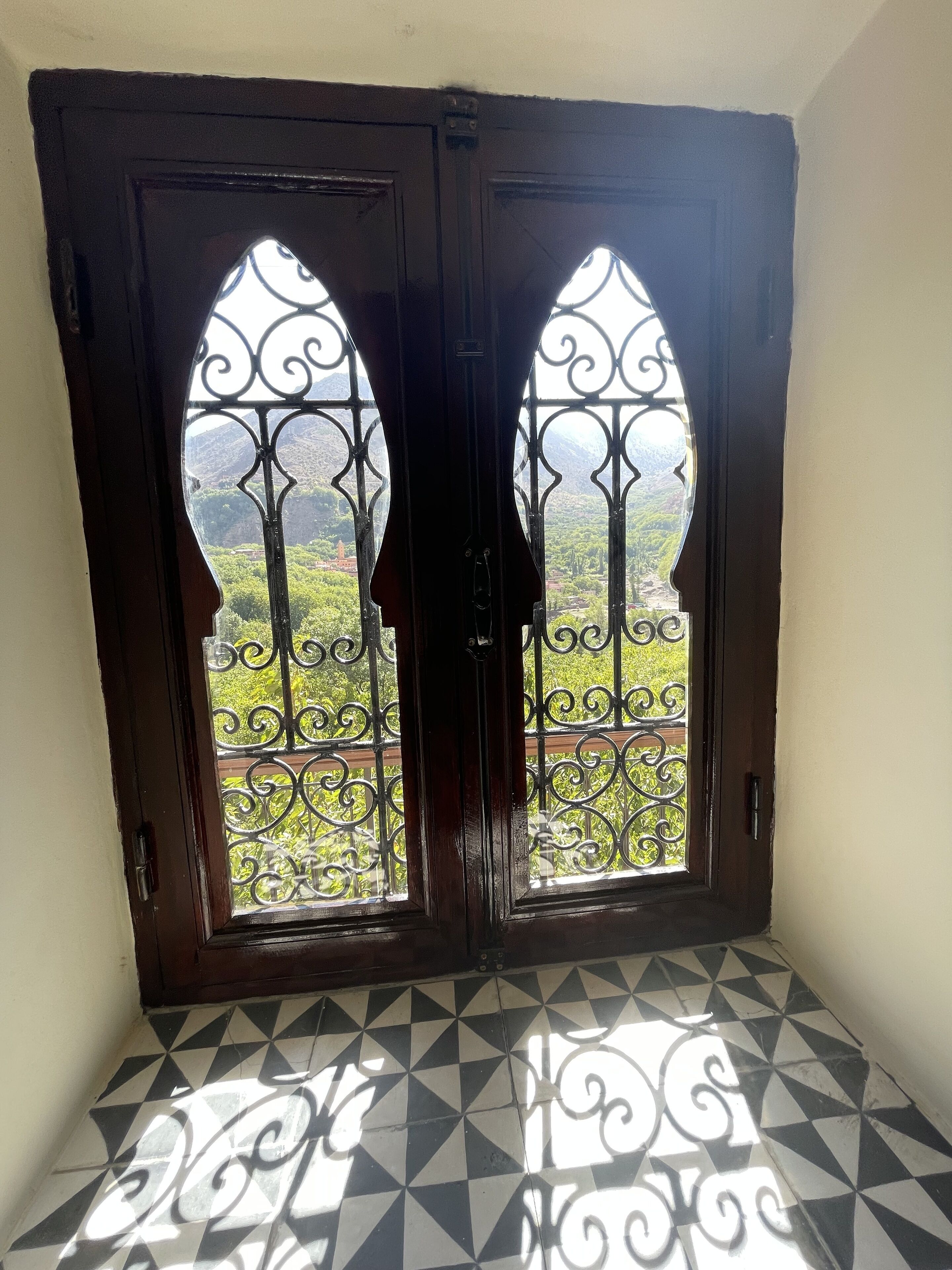 A room with a geometric patterned floor and a door with two arched windows.