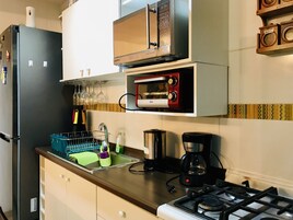 Cocina compacta con microondas, horno y cafetera integrados.