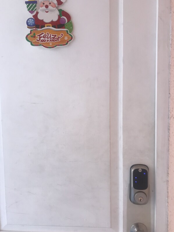 A white door with a Santa Claus sticker and a "Feliz Navidad" sign. - Cosmopolita (La Serena)