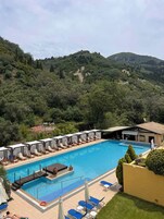 Una piscina al aire libre de temporada, sillones reclinables de piscina